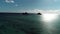 Honolulu, Hawaii, low angle view with drone camera pan shot, backlit island in open waters , color graded