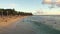 Honolulu, Hawaii - March 15 2021: Gorgeous Sunset on Honolulu's Waikiki beach. Surfers ride the waves. Tourists sunbathe