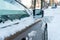 The hood and doors of the car are covered with snow and ice after a snowfall. Parked cars are coated with snow. Big frosts and a