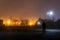 A hooded figure standing in an empty industrial estate on a misty winters night