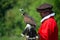 Hooded Harris Hawk on the glove of a man wearing a red Elizabethan costume.