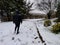 Hooded man climbing snowy stairs.