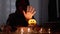 Hooded Shaman Boy Conjures over Pumpkin Candle in Dark Halloween Room