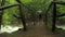 Hooded Tourist Walking On Bridge Hanging Above