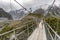 Hooker Valley Track hiking trail, New Zealand. Hikers people crossing bridge on the Hooker Valley track, Aoraki, Mt Cook