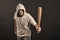 Hooligan wear hood in hoody, fashion. Man hold baseball bat, aggression. Gangster guy threaten with bat weapon