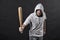 Hooligan wear hood in hoody, fashion. Man hold baseball bat, aggression. Gangster guy threaten with bat weapon. Aggression, anger