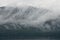 Hoonah, Alaska: Clouds and mist sweep across a dense forest of pine trees