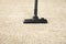 Hoovering beige carpet with modern vacuum cleaner