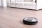 Hoovering floor with modern robotic vacuum cleaner. Space for text