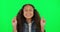 Hope, girl and excited with green screen and fingers crossed feeling happy with youth. Funny, smile and young child with