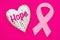 Hope message on weathered heart with pink cancer ribbon on bright pink