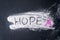 Hope text on sand with pink ribbon