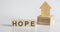 HOPE -Wooden Blocks With A Miniature House on white background