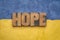 Hope word in vintage wood type agianst Ukraine colors