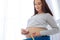 Hopeful pregnant woman scrutinizing her belly