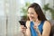 Hopeful woman waiting for online news in a smartphone