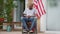 Hopeless desperate disabled African American man thinking sitting in wheelchair on backyard porch. Wide shot portrait of