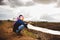 Hopeless Farmer sitting on dry ground with hoe on his shoulder. Global warming crisis