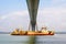 A hopper dredger sailing under the Normandy bridge in France