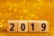 Horisontal numbers of 2019 on golden sparkling background.