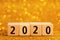 Horisontal numbers of 2020 on golden sparkling background.