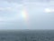 Horizon with distant ship and rainbow