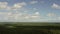 Horizon over forest with spots of light and cloudy sky long aerial panoramic view