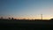 Horizon at Sunset with Silhouettes of Wind Turbine, Electricity and Farm Houses