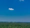 Horizontal aerial view to the horizon with blue sky, much copy space, a small cloud and windmills