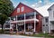 Horizontal autumnal view of tourists outside the historic family owned red wooden Vermont Country