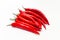 Horizontal bunch of oblong red chili peppers. White background isolated. Vitamins, healthy food