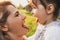 Horizontal close up portrait of happy joyful child and her beautiful mother playing outdoor. Cute woman and her daughter have fun