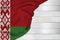 Horizontal colored national flag of the modern state of Belarus, beautiful silk, white wood background, concept of tourism,