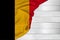 Horizontal colored national flag of modern state of Belgium, beautiful silk, white wood background, concept of tourism, economy,