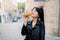 Horizontal fashion lifestyle shot of pretty glamorous brunette Asian woman, wearing stylish black leather jacket