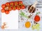 Horizontal food banner with cherry tomatoes, garlic, peppercorns, spice and notebook on wooden background. Empty space for text.