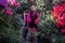 Horizontal funny photo of a young gardener girl sitting on a chair in a botanical garden