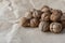 Horizontal handful of walnuts in the shell on an old mint kraft paper, a brown background, a warm beige pattern