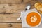 Horizontal image of bowl of tomato soup with spoon and toast on wooden table, copy space