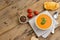 Horizontal image of bowl of tomato soup with tomatoes, toast and peppercorns on wood, copy space