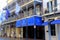 Horizontal image of bright and colorful businesses and vintage railings, New Orleans, 2016