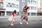 Horizontal image of a little girl playing hopscotch with her mother on a playground outside. A happy child plays with her mom. Kid