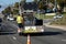 Horizontal image of Worker behind utility truck placing bright orange traffic cones on roadway