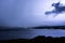 Horizontal lightning strike over lake and mountain range