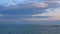 Horizontal line between blue sea and purple sky with horizon line at sunset. Wave in the sea.