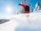 Horizontal low angle shot of a snowboarder riding the slope on a sunny winter day in the mountains