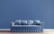 Horizontal mock-up poster, modern interior design, tufted sofa, blue wall background with free space above on top