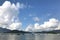 Horizontal mountain, blue sky, sailboat and cloudscape on lake
