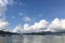 Horizontal mountain, blue sky, sailboat and cloudscape on lake